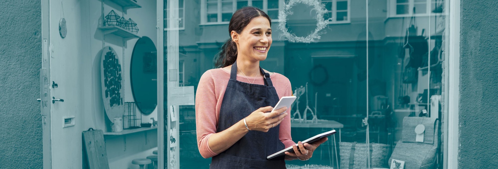 Mujer gestionando pedidos en tienda con móvil y tablet - Asendia