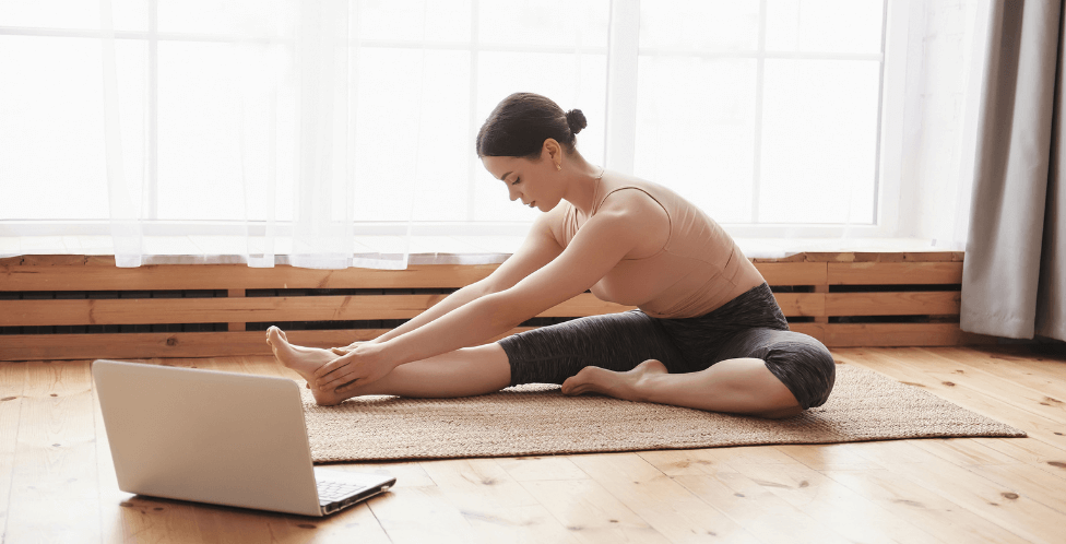 Mujer sobre una esterilla de yoga en una habitación luminosa