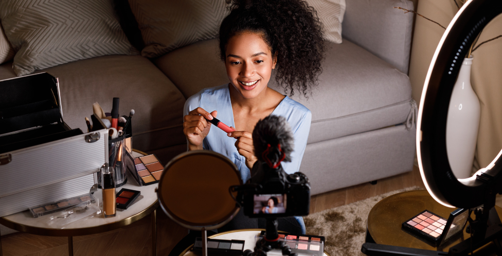 Mujer frente a móvil creando contenido de producto de belleza 